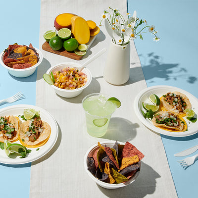 Repurpose Kitchen Table Bundle featuring our Repurpose 100% Compostable 10" Dinner Plates, Repurpose 100% Compostable 16oz Bigger Bowls, Repurpose 100% Compostable Cold Cups, and Repurpose Compostable Assorted Cutlery is great for themed dinners like tacos and salsa night.