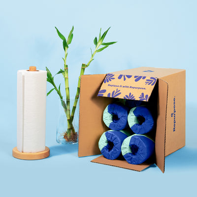 Repurpose Premium Bamboo Paper Towels in pack shipment surrounded by a paper towel holder and bamboo.